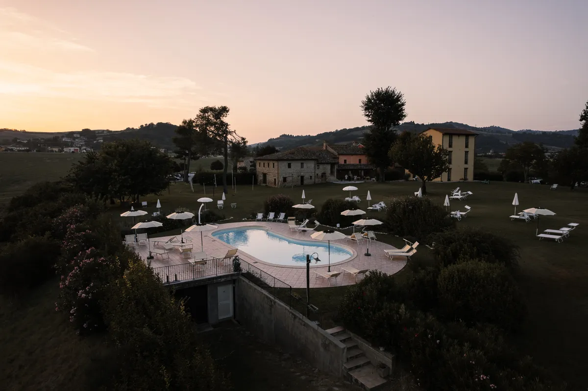 Il giardino e la piscina di Ca' Virginia illuminati al crepuscolo, cornice all'aperto per cerimonie